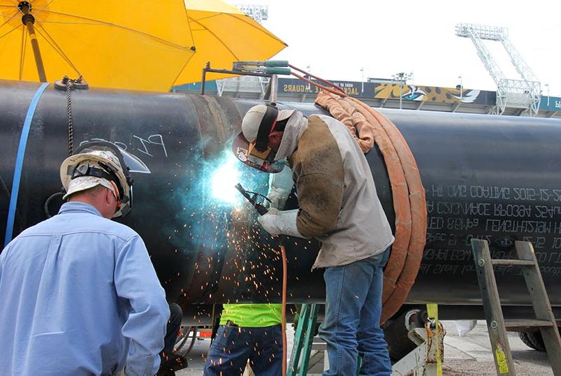 Welding crew joining pipe sections