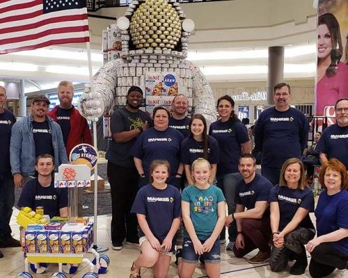 CANstruction team members pose with the award winning "Food Can Space Man" can sculpture, benefitting the Salvation Army Central Oklahoma Area Command Food Pantry.