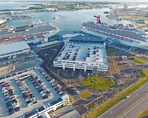 卡纳维拉尔港口管理局5号邮轮码头的航拍照片. 港口有两艘游轮. 其中一艘船停靠在新的两层旅客和行李处理区. 大型停车场.