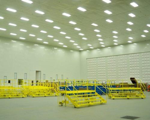 Interior of Gulfstream Paint Hangar. Large empty room with white walls and fluorescent lighting.