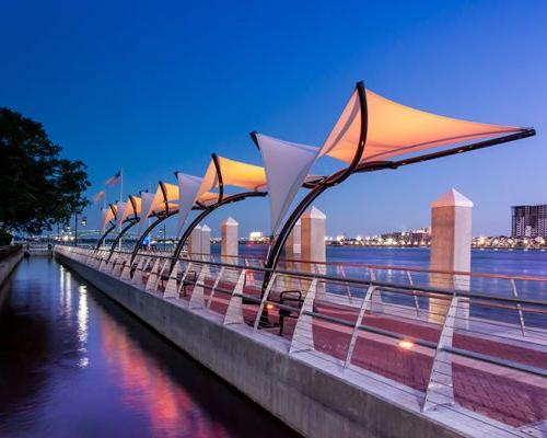Photo of Jacksonville's Southbank Riverwalk at dusk. LED lights change colors and illuminate the canopies.